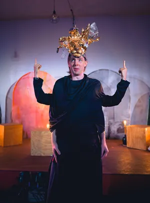 Robin McGinness in Alceste (In Series) — gold lion headdress, fingers raised